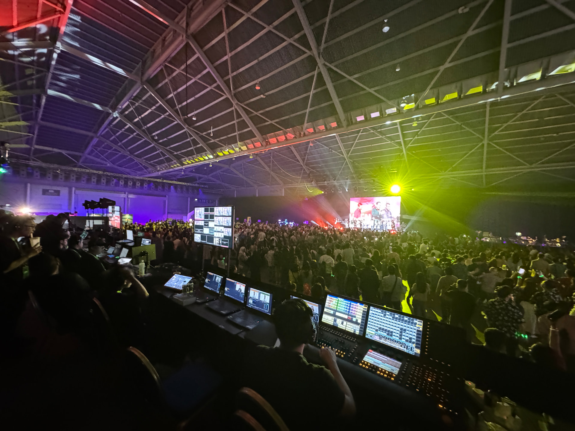 Corporate conference stage with LED wall, presenter and live production control desk in Singapore